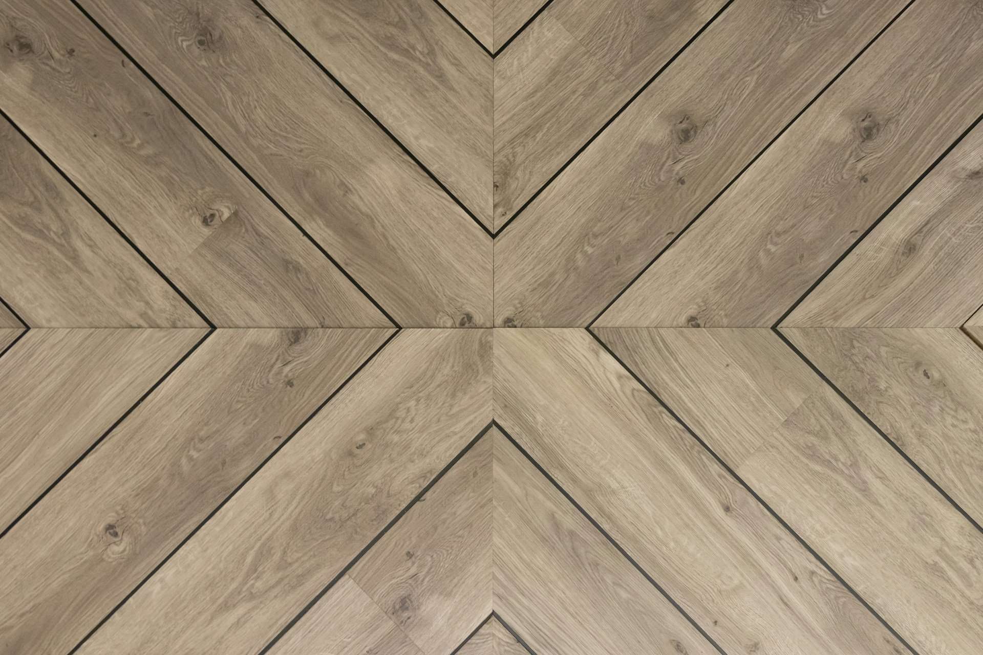 Close-up of herringbone style vinyl or laminate flooring with natural wood texture
