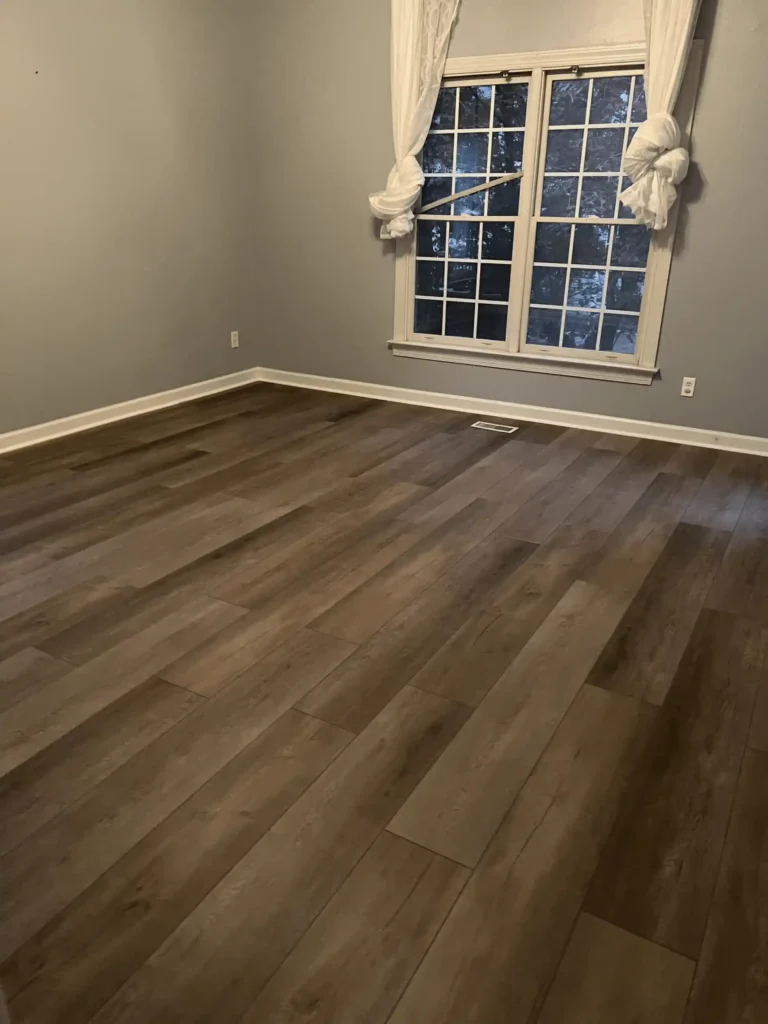 Dark wood-look vinyl plank flooring installed in an empty room