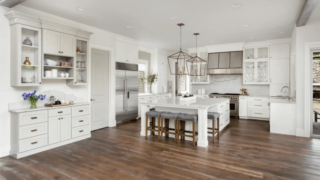 Dark hardwood flooring installed in a bright white kitchen